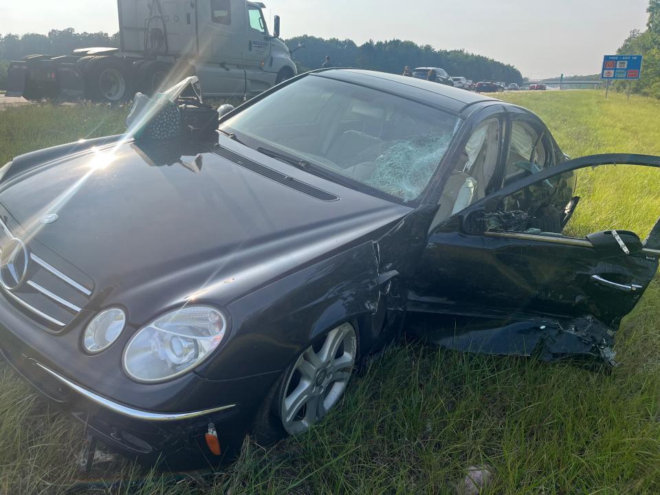 Ann Shuman's Mercedes sits in the shoulder along Interstate 77 after it was struck by a black SUV Thursday. The driver of the SUV was shot while driving southbound before he jumped the median into the northbound lanes, striking Shuman.