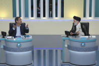 In this picture made available by Young Journalists Club, YJC, presidential candidate for June 18, elections Abdolnasser Hemmati, left, speaks as Ebrahim Raisi listens in the final debate of the candidates, at a state-run TV studio in Tehran, Iran, Saturday, June 12, 2021. Iran's seven presidential candidates offered starkly different views Saturday in the country's final debate, with hard-liners describing those seeking ties with the West as "infiltrators" and the race's sole moderate warning a hard-line government would only bring more sanctions for the Islamic Republic. (Morteza Fakhri Nezhad/ Young Journalists Club, YJC via AP)