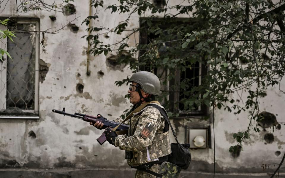 A Ukrainian serviceman stands in the city of Lysytsansk in the Donbas  - ARIS MESSINIS / AFP