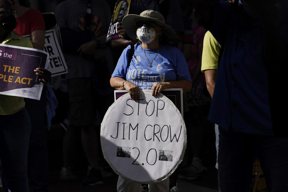 FILE - A demonstrator holds a sign reading "Stop Jim Crow 2.0" during a march for voting rights, to commemorate the 58th anniversary of the March on Washington on Saturday, Aug. 28, 2021, in Atlanta. Hundreds of thousands of voting rights advocates rallied across the country Saturday to call for sweeping protections against a further erosion of the Voting Rights Act of 1965. (AP Photo/Brynn Anderson, File)