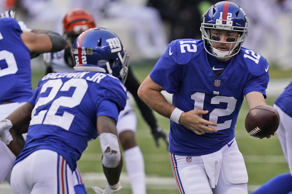 New York Giants quarterback Colt McCoy (12) hands off the ball to running back Wayne Gallman (22) during the second half of an NFL football game against the Cincinnati Bengals, Sunday, Nov. 29, 2020, in Cincinnati. (AP Photo/Bryan Woolston)