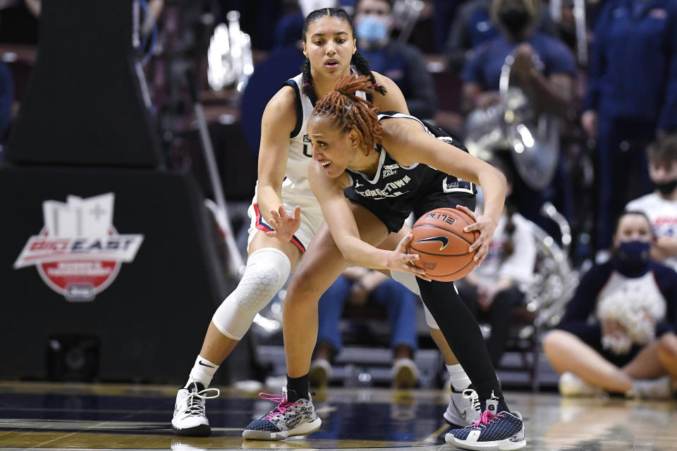 Connecticut's Azzi Fudd, back, guards Georgetown's Jillian Archer in the first half of an NCAA college basketball game in the quarterfinals of the Big East Conference tournament at Mohegan Sun Arena, Saturday, March 5, 2022, in Uncasville, Conn. (AP Photo/Jessica Hill)