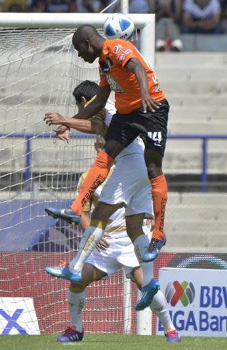 El delantero Enner Valencia (arriba), del Pachuca, cabecea ante la marca de Marco Antonio Palacios y Darío Verón (atrás), ambos de los Pumas, durante el partido entre ambos equipos por el torneo Clausura-2014 del fútbol mexicano jugado el 2 de marzo de 2014 en Ciudad de México (AFP/Archivos | Omar Torres)