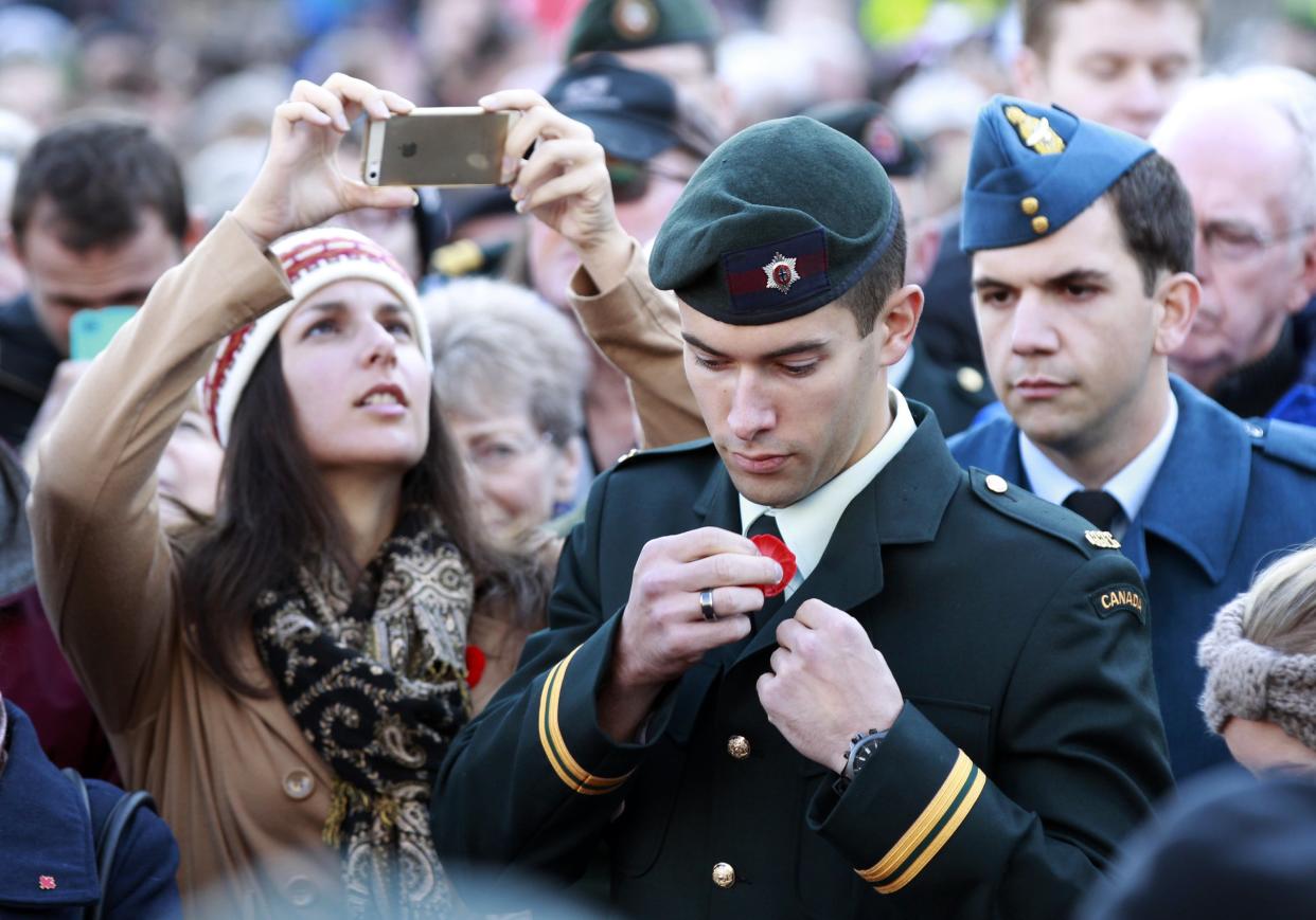 A Canadian Forces member removes his poppy at the Tomb of the Unknown Soldier Nov. 11, 2014. (Reuters)