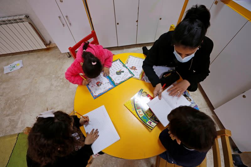 Un miembro del personal enseña a los niños en The Creche, una casa que alberga a los niños, en Belén, Palestina