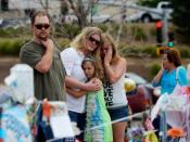 Una familia de Aurora (Colorado) se emociona ante el altar en memoria de las víctimas del tiroteo del estreno de Batman. Al menos un hombre y un agente de policía murieron y otras cuatro personas resultaron heridas este lunes cerca de una universidad de Texas (centro-sur de EEUU), en un tiroteo perpetrado por un "pistolero activo" que fue detenido, informó una fuente policial. (AFP/GETTY IMAGES | kevork djansezian)