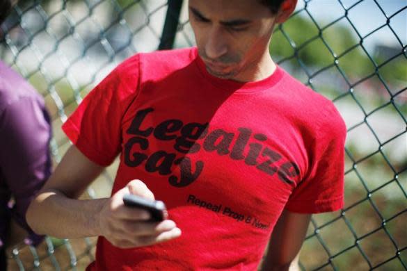 A man checks his mobile phone as civil unions supporters rally in downtown Denver before the Colorado House Judiciary Committee hearing on the Colorado Civil Union Act in Denver May 3, 2012. The bill passed the Colorado Senate last week.