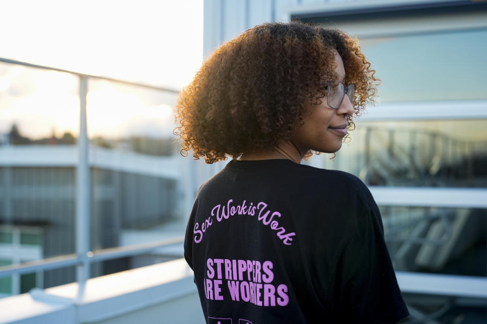 Andrea, no last name given, who works as a stripper in Seattle area clubs, poses for a portrait at her apartment, Thursday, Feb. 1, 2024, in Seattle. Andrea is among those fighting for bills to pass in the state Legislature that would expand statewide protections to workers, like having a security guard at each club, keypad codes to enter dressing rooms and de-escalation training. (AP Photo/Lindsey Wasson)