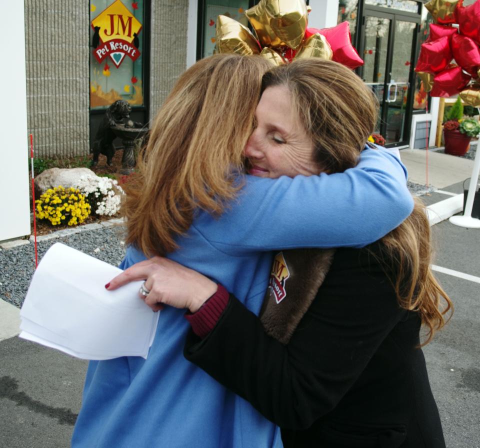 Wed., Nov. 17, 2021, Amy Baxter, left, owner of the dog named Ollie, who who was mauled and soon died while staying in a pet daycare facility, gets a hug from Jeni Mather, owner of the JM Pet Resort in Brockton, after the rally in support of "Ollie's Law" (H.305) came to an end. Both women spoke to the gathered crowd of the need to better regulate pet care and kennels in order to prevent the tragic attacks like the one that killed Baxter's 7-month-old puppy.