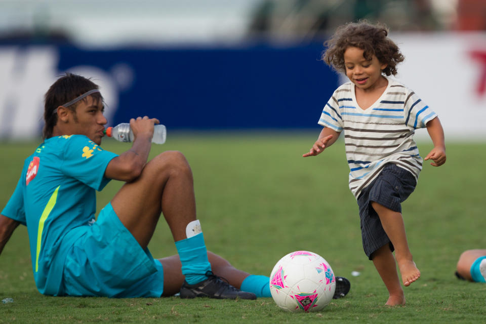 Brazil's Marcelo's son Enzo, right, plays the ball past Brazil's Neymar at the end of a training session in preparation for the London 2012 Olympics in Rio de Janeiro, Brazil, Wednesday July 11, 2012. (AP Photo/Felipe Dana)