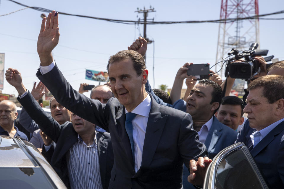 FILE - Syrian President Bashar Assad, center, waves to his supporters at a polling station during the Presidential elections in the town of Douma, in the eastern Ghouta region, near the Syrian capital Damascus, Syria, May 26, 2021. Assad was in Tehran on Sunday, May 8, 2022 meeting Iranian leaders, Iranian state-linked media reported, marking his second trip to Tehran since Syria’s civil war erupted in 2011. (AP Photo/Hassan Ammar, file)