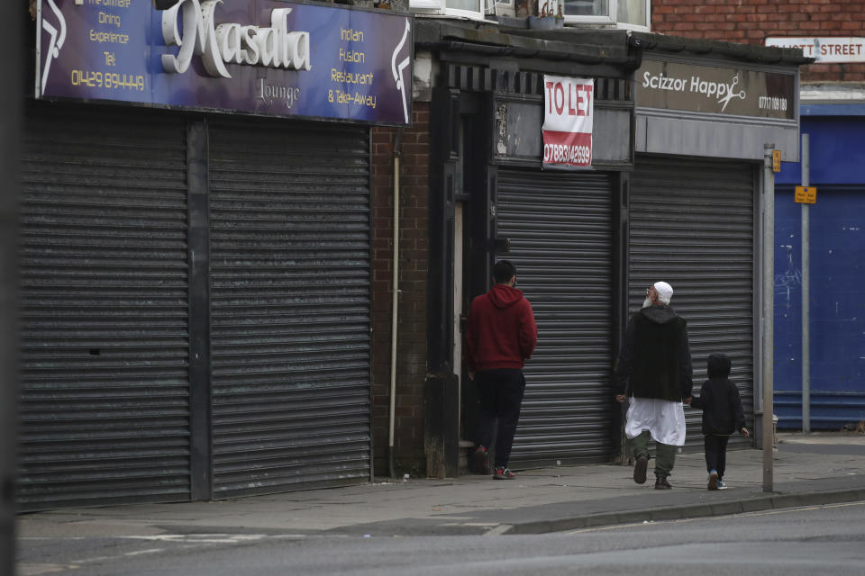 FILE - People walk past some shuttered and closed shops in Hartlepool northeast England, Saturday, June 29, 2024. As British voters prepare to choose a new government on Thursday, Hartlepool's statistics still tell a sobering story. Compared the country as a whole, it has higher unemployment, lower pay, shorter life expectancy, more drug deaths and worse crime rates. (AP Photo/Scott Heppell, File)