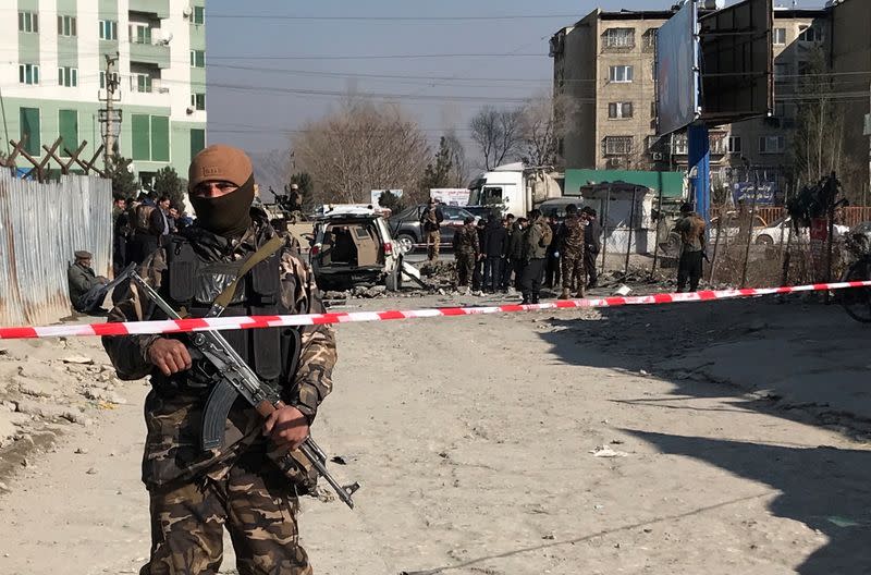 An Afghan security officer keeps watch at the site of a blast in Kabul