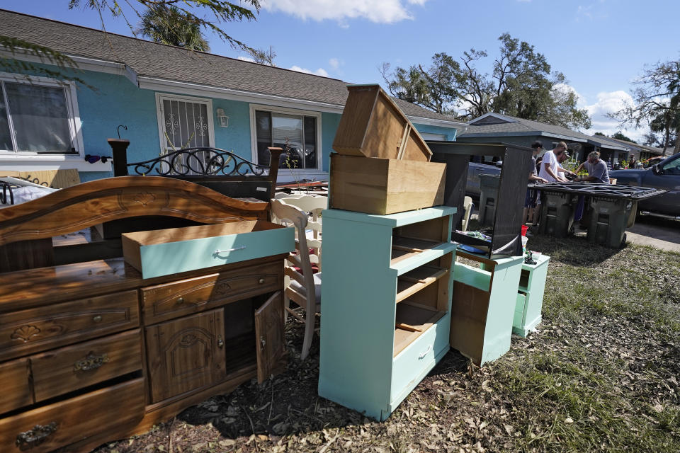 Residents clean up water soaked furniture from their homes Tuesday, Oct. 4, 2022, in North Port, Fla. Residents along Florida's west coast continue to clean up after Hurricane Ian made landfall last week. (AP Photo/Chris O'Meara)