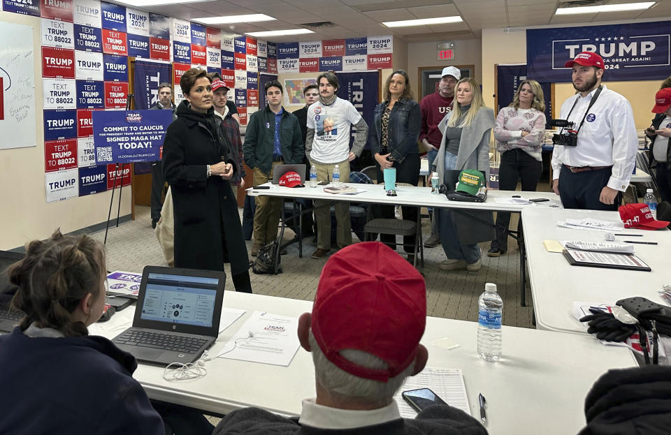 Arizona Senate candidate Republican Kari Lake, standing left, speaks to volunteers at former president Donald Trump's campaign headquarters in the closing days ahead of the GOP Iowa caucus on Saturday, Jan. 13, 2024, in Urbandale, Iowa. (AP Photo/Jill Colvin)