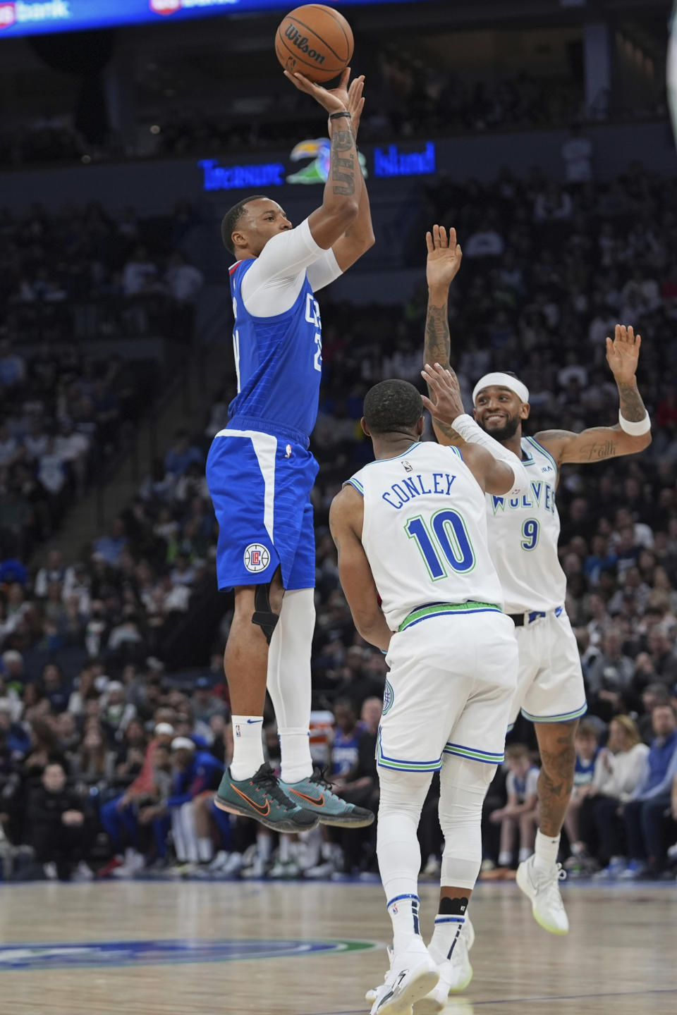 Los Angeles Clippers guard Norman Powell, left, goes up to shoot over Minnesota Timberwolves guards Mike Conley (10) and Nickeil Alexander-Walker (9) during the first half of an NBA basketball game, Sunday, March 3, 2024, in Minneapolis. (AP Photo/Abbie Parr)
