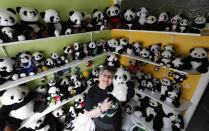 Celine Cornet holds a panda soft toy, part of a collection of 2,200 pieces of panda collectables, in her house in Haccourt March 11, 2014. REUTERS/Yves Herman