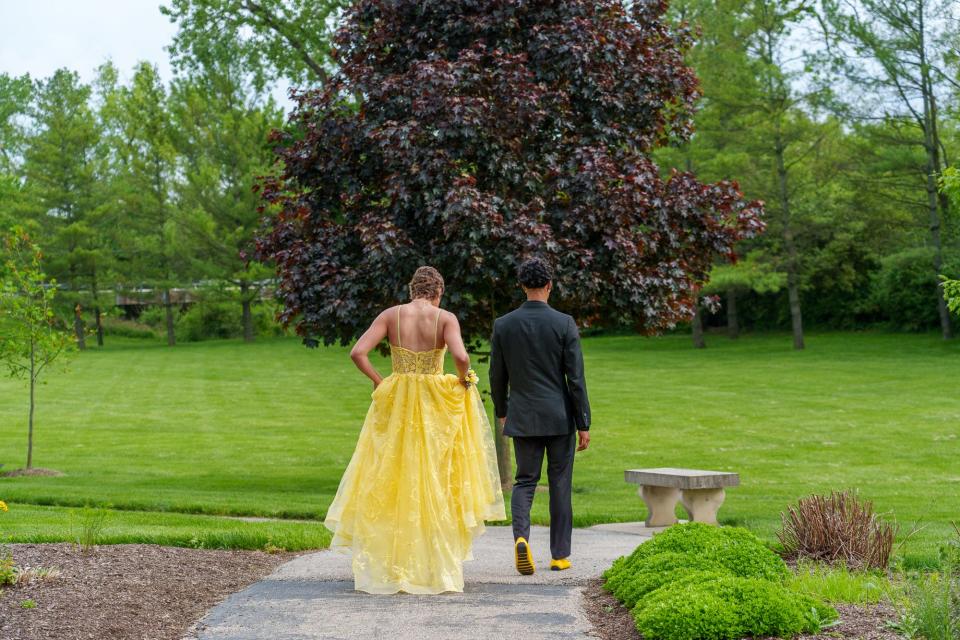 Cade Thompson walks with date Vivian Eagle at Friendship Gardens Park in Plainfield on Saturday, May 13, 2023, ahead of Avon's prom. Both Thompson and Eagle had and beat osteosarcoma, a cancer of the bone. The cancer ribbon color of osteosarcoma is yellow.
