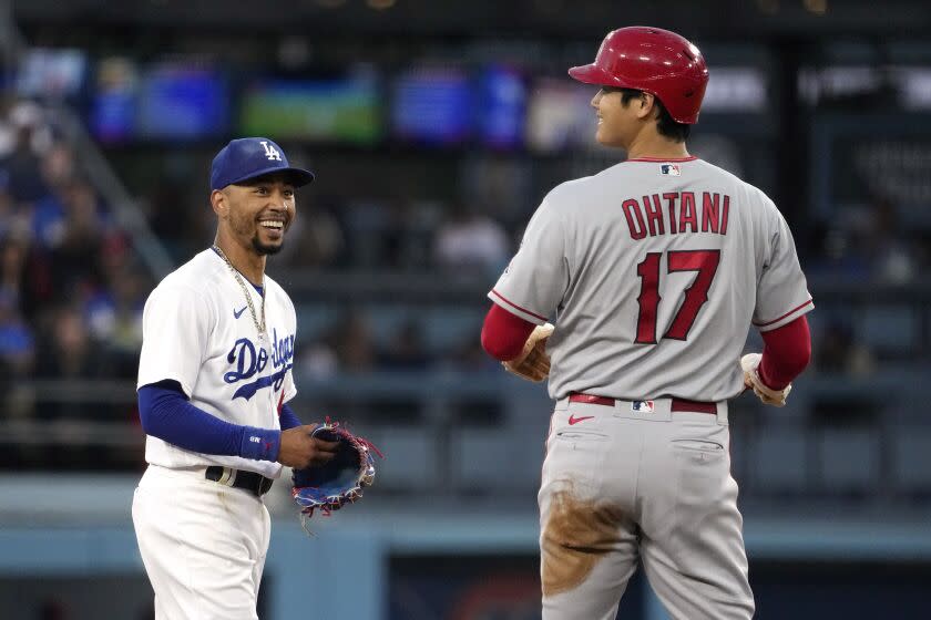 Dodgers second baseman Mookie Betts chats with two-way Angels star Shohei Ohtani on the field