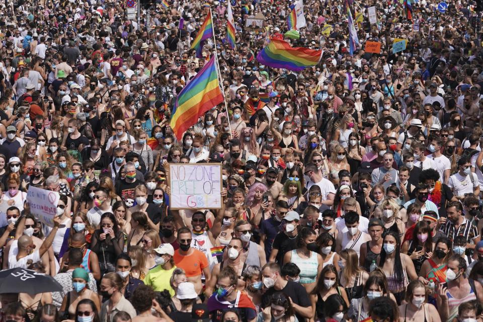 Thousands of people take part in the Christopher Street Day (CSD) parade, with the Brandenburg Gate in the background in Berlin, Germany, Saturday July 24, 2021. (Jorg Carstensen/dpa via AP)