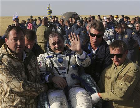 Russia's space agency ground personnel carry Russian cosmonauts Pavel Vinogradov (C) and Alexander Misurkin (back R) and US astronaut Chris Cassidy (back L) shortly after landing of the Soyuz TMA-08M space capsule some 146 km southeast of the town of Zhezkazgan in Kazakhstan, September 11, 2013. REUTERS/Maxim Shipenkov/Pool