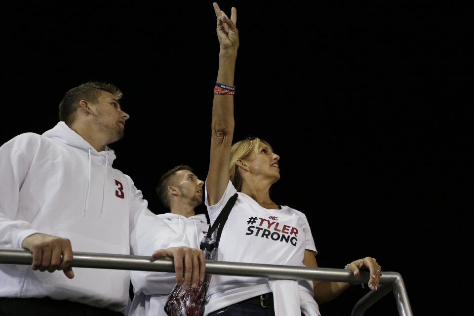 Kym Hilinski, right, watches the video board with her sons Ryan Hilinski, left, and Kelly Hilinski before an NCAA college football game between Washington State and San Jose State in Pullman, Wash., Saturday, Sept. 8, 2018. Kym Hilinski's son Tyler Hilinski, who was a Washington State quarterback, died as a result of suicide in January. (AP Photo/Young Kwak)