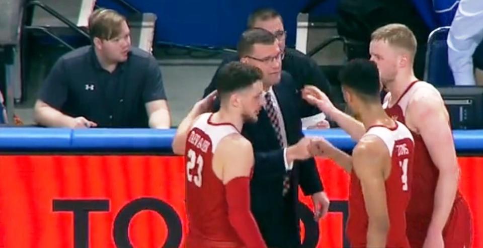 Bradley players Ville Tahvanainen (left), Malevy Leons (middle) and Rienk Mast (right) gather around head coach Brian Wardle to support him after he was whistled for a technical by a referee who tried to walk into the team's huddle during a timeout late in the game Wednesday at Indiana State.