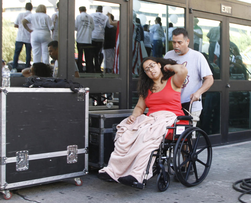 CORRECTS TO AUG. 10, NOT 8 - Jessica Coca Garcia is wheeled away after speaking at League of United Latin American Citizens' "March For a United America," in El Paso, Texas, on Saturday, Aug. 10, 2019, a week after she and her husband were injured by bullets during a mass shooting. More than 100 people marched through the Texas border denouncing racism and calling for stronger gun laws one week after several people were killed in a mass shooting that authorities say was carried out by a man targeting Mexicans. (AP Photo/Cedar Attanasio)