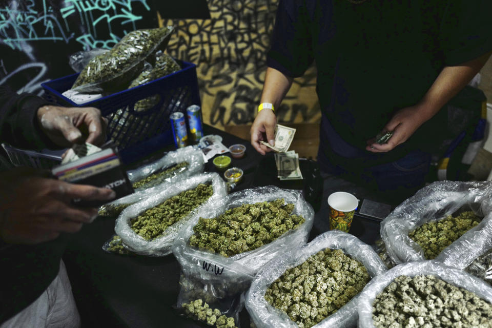 FILE - In this April 15, 2019, file photo, a vendor makes change for a marijuana customer at a cannabis marketplace in Los Angeles. Voters in four states could embrace broad legal marijuana sales on Election Day, setting the stage for a watershed year for the industry that could snowball into neighboring states as well as reshape policy on Capitol Hill. The Nov. 3, 2020, contests will take place in markedly different regions of the country, New Jersey, Arizona, South Dakota and Montana and approval of the proposals would highlight how public acceptance of cannabis is cutting across geography, demographics and the nation's deep political divide. (AP Photo/Richard Vogel, File)