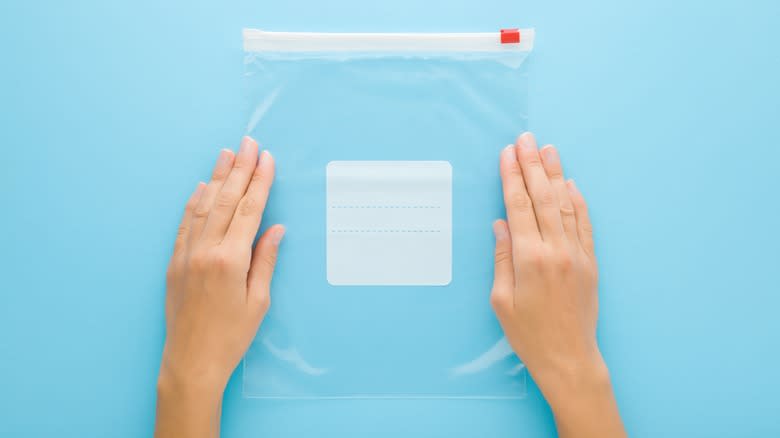 Hands flattening Ziploc bag