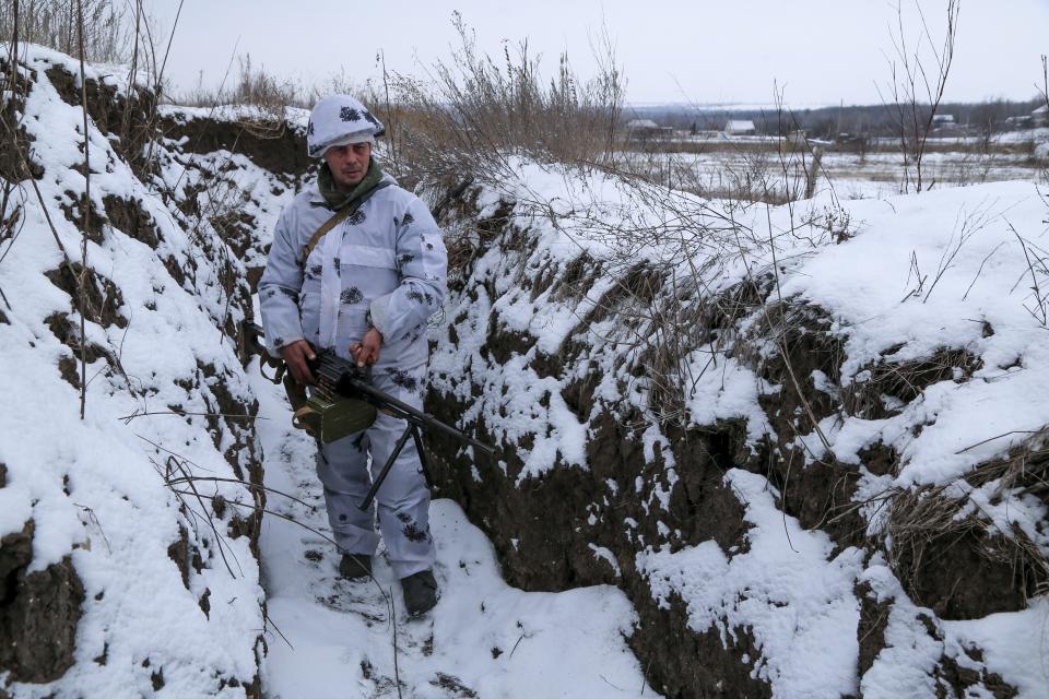 A serviceman stands holding his machine-gun in a trench on the territory controlled by pro-Russian militants at frontline with Ukrainian government forces in Slavyanoserbsk, Luhansk region, eastern Ukraine, Tuesday, Jan. 25, 2022. Ukraine's leaders sought to reassure the nation that a feared invasion from neighboring Russia was not imminent, even as they acknowledged the threat is real and prepared to accept a shipment of American military equipment Tuesday to shore up their defenses. (AP Photo/Alexei Alexandrov)