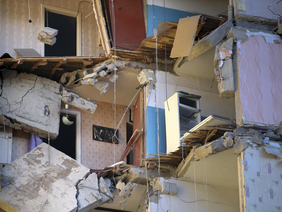 The scene of a part of a collapsed apartment building in Magnitogorsk, a city of 400,000 people, about 1,400 kilometers (870 miles) southeast of Moscow, Russia, Monday, Dec. 31, 2018. At least four people died Monday when sections of an apartment building collapsed after an apparent gas explosion in Russia's Ural Mountains region, officials said. (AP Photo/Maxim Shmakov)