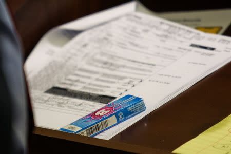 A pack of Bubblicious gum rests upon an Enterprise rental agreement on the lectern during the murder trial for former New England Patriots player Aaron Hernandez at the Bristol County Superior Court in Fall River, Massachusetts, February 18, 2015. REUTERS/Dominick Reuter/Pool