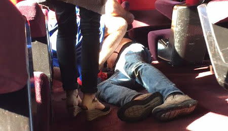 A man lies on the on floor in the Amsterdam to Paris Thalys high-speed train where shots were fired and several people were injured, according to the French interior ministry, in Arras, France, August 21, 2015. REUTERS/Christina Cathleen Coons/Handout via Reuters