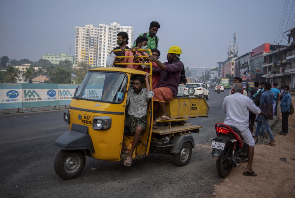 Migrant laborers wearing masks as a precaution against the coronavirus leave for work in Kochi, Kerala state, India, Thursday, Feb. 18, 2021. The southern state, which had previously been hailed as a blueprint for tackling the virus now accounts for nearly half of India's current COVID-19 cases. (AP Photo/R S Iyer)