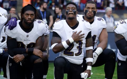 Baltimore Ravens strong safety Tony Jefferson (23) and Baltimore Ravens outside linebacker Matt Judon, left, kneel down with teammates during the playing of the U.S. national anthem before an NFL football game against the Jacksonville Jaguars at Wembley Stadium - Credit: AP