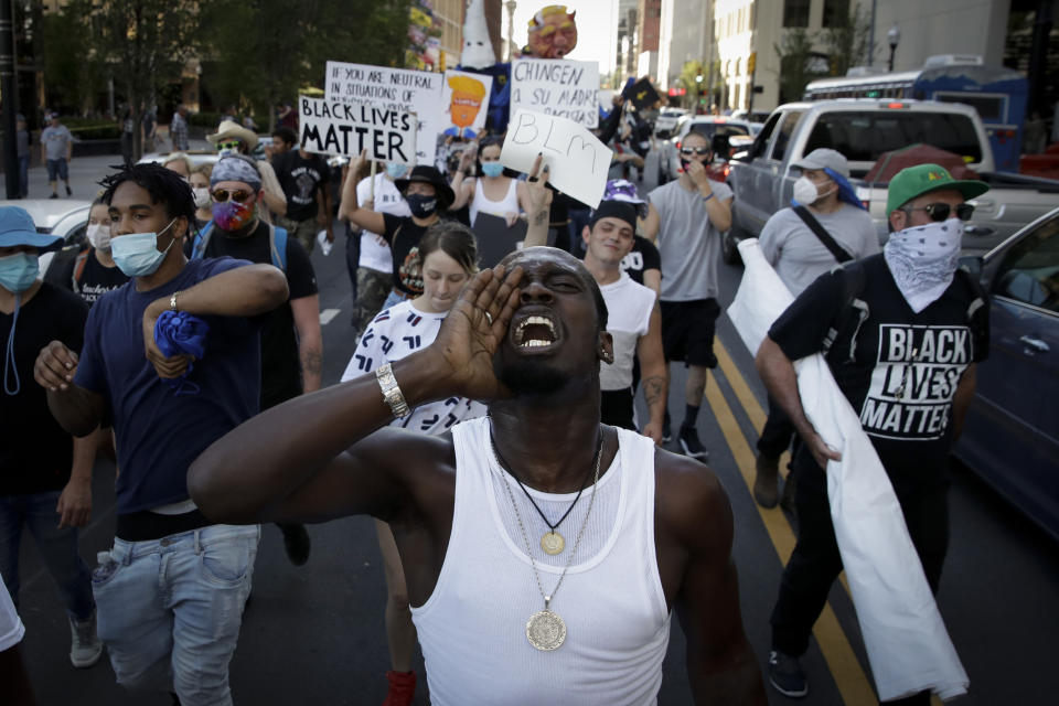 FILE - In this June 20, 2020, file photo, demonstrators march outside the BOK Center where President Trump will hold a campaign rally in Tulsa, Okla. (AP Photo/Charlie Riedel, File)