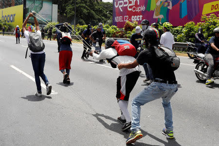 Demonstrators use a giant sling shot during a rally against Venezuela's President Nicolas Maduro in Caracas, Venezuela, May 26, 2017. REUTERS/Marco Bello