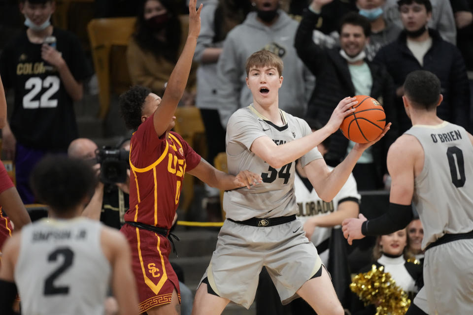 Colorado center Lawson Lovering, center, looks to pass the ball to guard Luke O'Brien, right, as Southern California guard Boogie Ellis defends during the first half of an NCAA college basketball game Thursday, Jan. 20, 2022, in Boulder, Colo. (AP Photo/David Zalubowski)