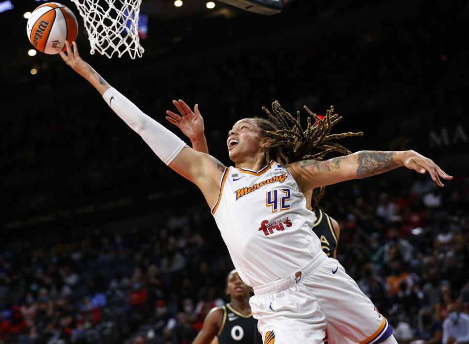 Phoenix Mercury center Brittney Griner (42) shoots next to Las Vegas Aces center Liz Cambage, obscured, during the first half of Game 5 of a WNBA basketball playoff series Friday, Oct. 8, 2021, in Las Vegas. (AP Photo/Chase Stevens)