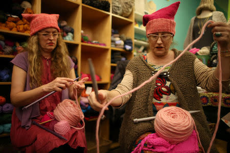 Molly Cleator (R) takes part in the Pussyhat social media campaign to provide pink hats for protesters in the women's march in Washington, D.C., the day after the presidential inauguration, in Los Angeles, California, U.S., January 13, 2017. REUTERS/Lucy Nicholson