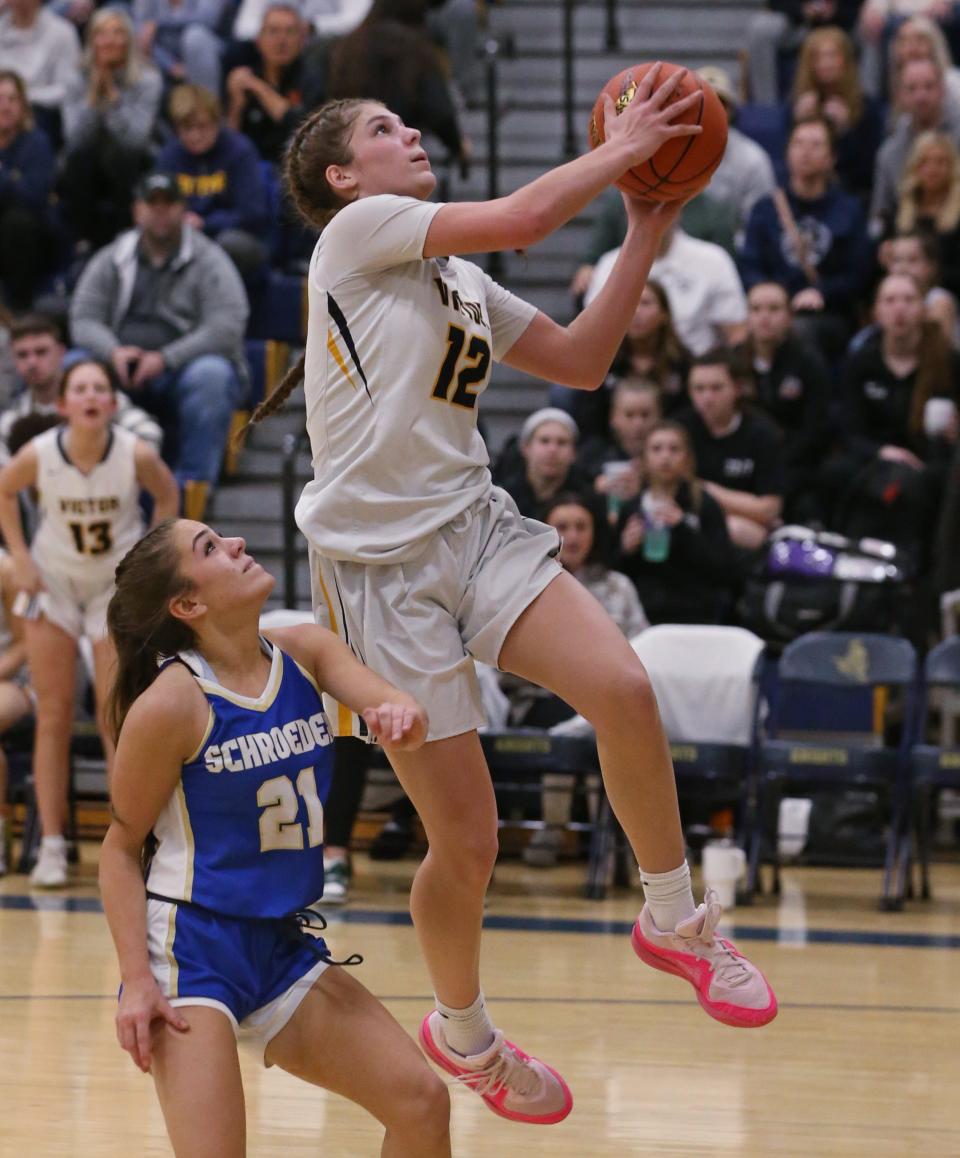 Victor's Rhylin Fehrenbach drives in for the bucket and the foul on Schroeder's Mya Perales in the fourth quarter.