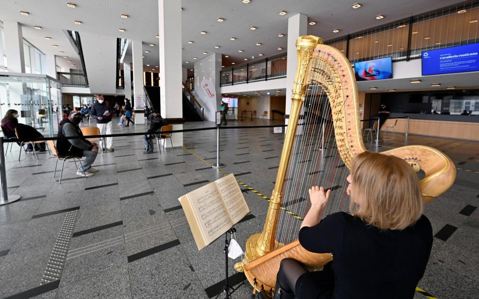 Harpist Sarah Christ performs in a COVID-19 rapid test centre which is located in the Palace of Culture amid the coronavirus pandemic - REUTERS/Matthias Rietschel