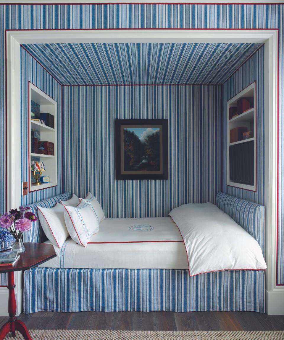 Blue stripped wallpaper, inbuilt white shelves, bed