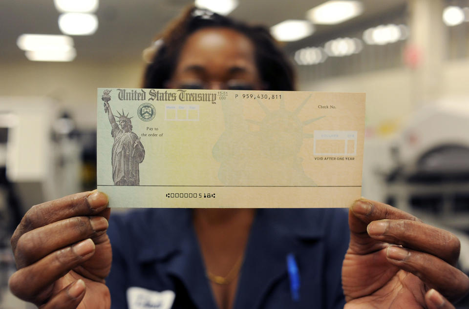 PHILADELPHIA, PA - JULY 18:  In this photo illustration, Treasury employee Linda Tarkenton of Philadelphia, Pennsylvania holds a blank U.S. Treasury check before it's run through a printer at the U.S. Treasury printing facility July 18, 2011 in Philadelphia, Pennsylvania. U.S. President Barack Obama recently stated that he can't guarantee retirees will receive their Social Security checks in August if the House and Senate can not reach an agreement on reducing the deficit.  (Photo by William Thomas Cain/Getty Images)