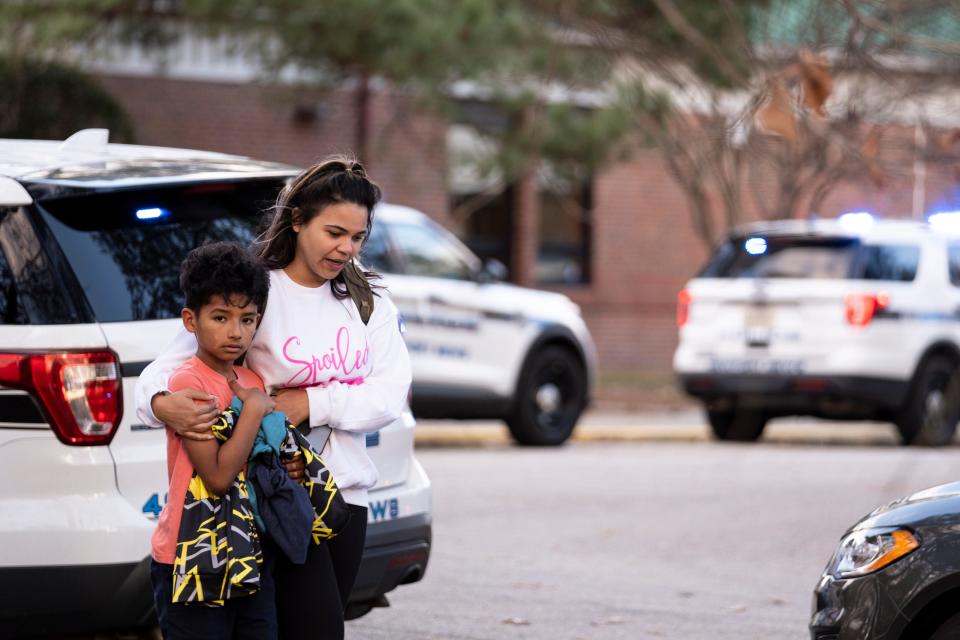 Carlos Glover, age 9,  a fourth grader at Richneck Elementary School, is held by his mother Joselin Glover as they leave the school, Friday, Jan. 6, 2023 in Newport News, Va. A shooting at a Virginia elementary school sent a teacher to the hospital and ended with “an individual” in custody Friday, police and school officials in the city of Newport News said. (Billy Schuerman/The Virginian-Pilot via AP) ORG XMIT: VANOV103