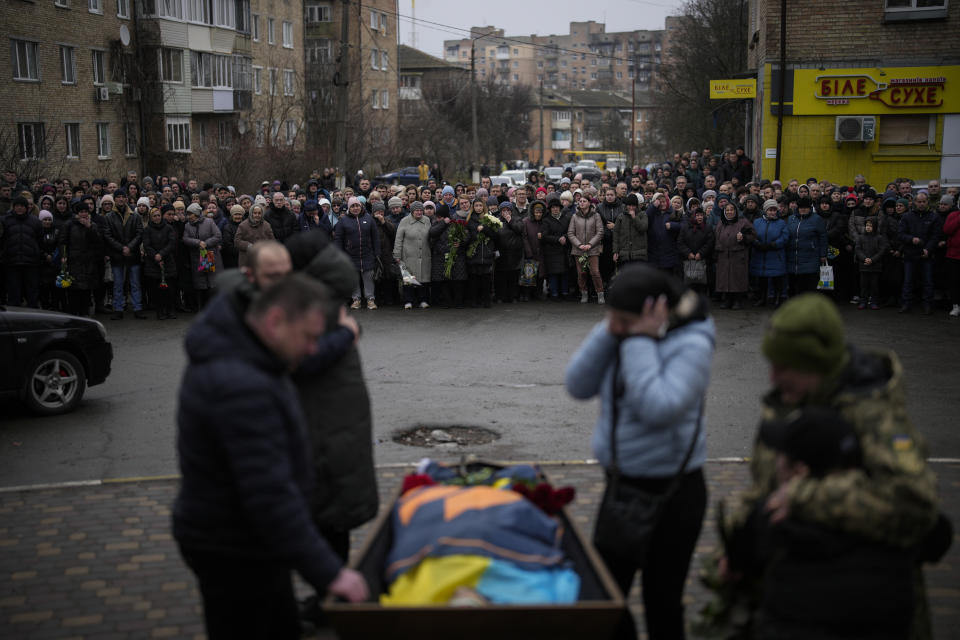 Bucha residents gather as Anna Korostenska and relatives mourn over the body of Oleksii Zavadskyi, a Ukrainian serviceman who died in combat on Jan. 15 in Bakhmut during his funeral in Bucha, Ukraine, Thursday, Jan. 19, 2023. (AP Photo/Daniel Cole)