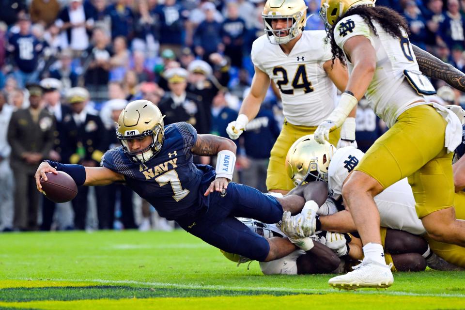 Navy quarterback Xavier Arline (7) runs the ball and dives into the end zone for a touchdown during the second half of an NCAA college football game against Notre Dame, Saturday, Nov. 12, 2022, in Baltimore. (AP Photo/Terrance Williams)