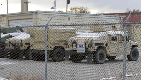 Snow-covered military vehicles parked behind Missouri National Guard depot, after a state of emergency was declared by Missouri Governor Jay Nixon, in St Louis, November 17, 2014. REUTERS/Tom Gannam