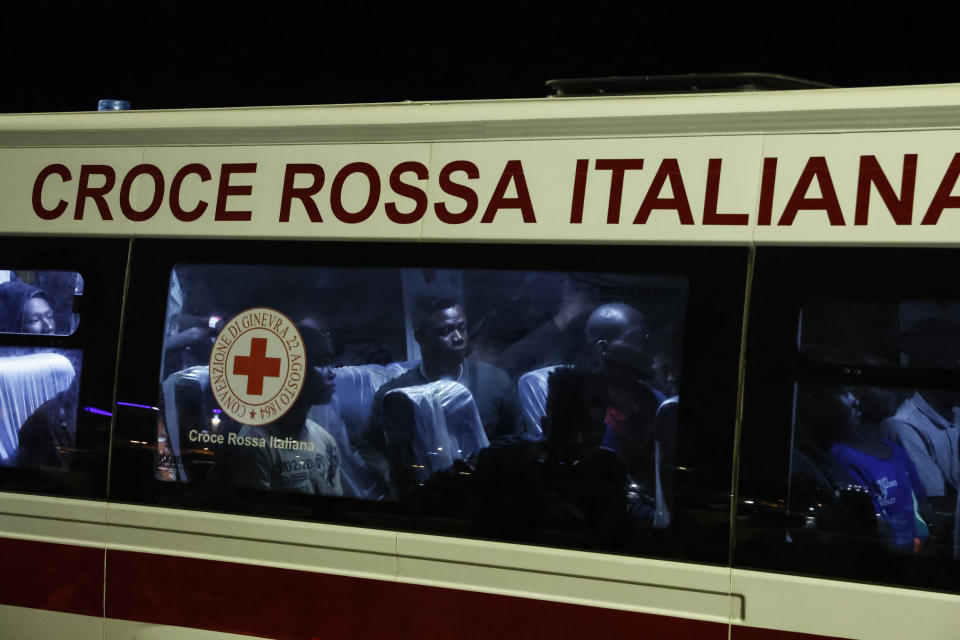 Rescued migrants sit in a bus after disembarking from a boat on the Italian island of Lampedusa during the evening of Saturday, Sept. 16, 2023. Tensions on the small island were rising Saturday, as both residents and migrants chafed at the long wait times to transfer people from the crowded reception center to the Italian mainland. Nearly 7,000 migrants arrived on Lampedusa from Tunisia this week, and the Red Cross said that 3,800 remained on the island on Friday. (Cecilia Fabiano/LaPresse via AP)